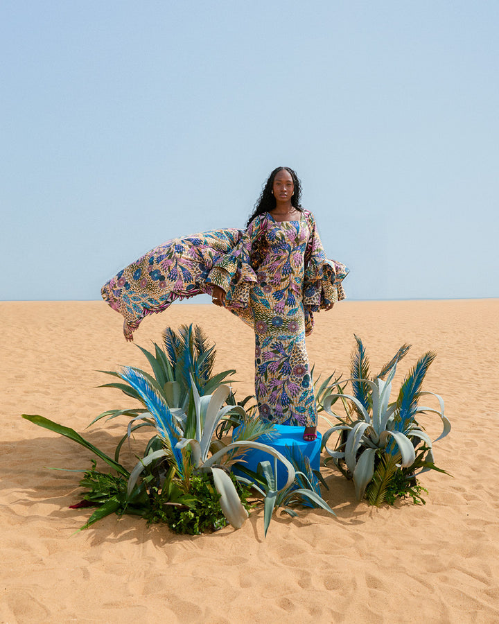 Woman in patterned dress showcasing Grand Super-Wax African fabric with blue-copper shine